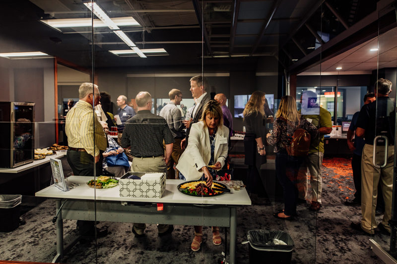 Chortek Summer 2019 Open House - guests in the conference room eating food from Sendik's and talking