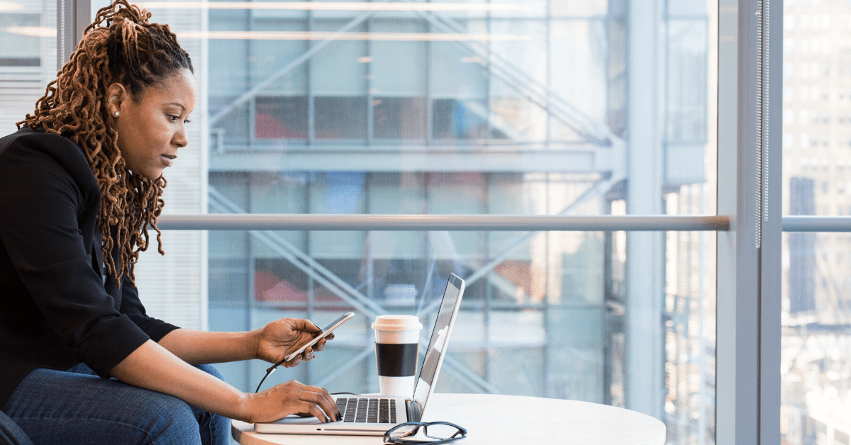 Woman on her laptop, holding her phone, and multitasking - Header image for Friendly Tips for 1099 Filing from Chortek LLP