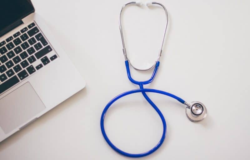 PCOR Fees - Image of a stethoscope beside a laptop