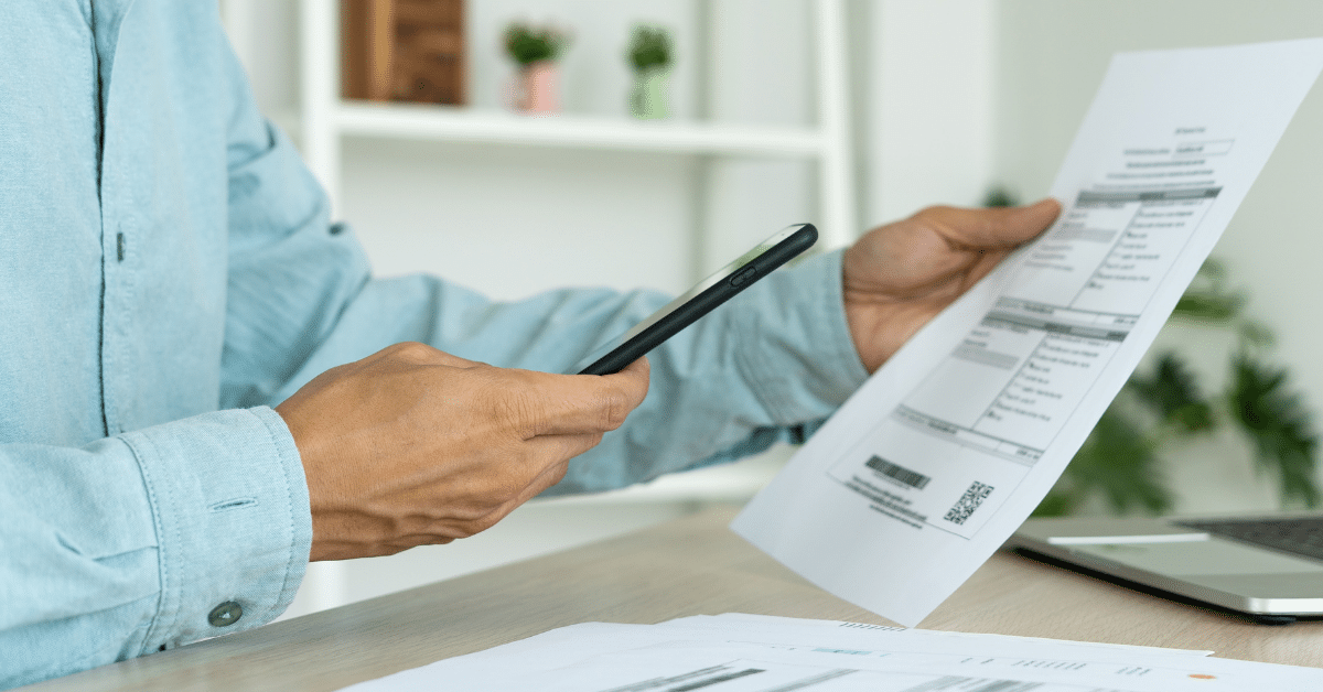 How to Send a Receipt on the QuickBooks App - Image of a man scanning a receipt using his phone